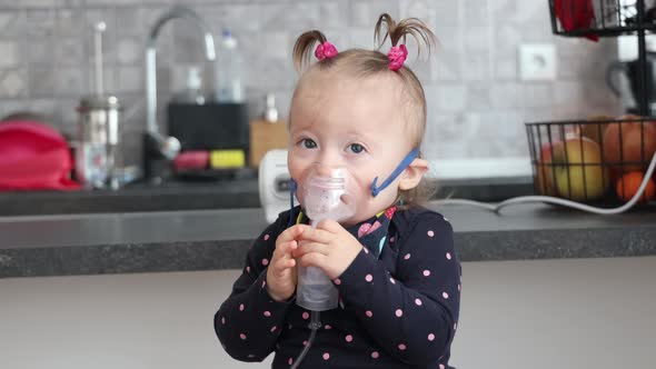 Cute little girl in the mask of an inhaler. Procedure of inhalation at home.