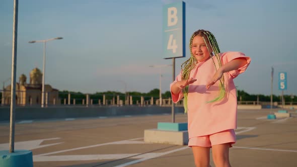 Young girl dancer dancing hip hop in the car parking. Youth subculture. Stylish Caucasian girl