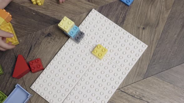 Unrecognizable Child Kid Hands Playing Colorful Plastic Building Blocks Indoors