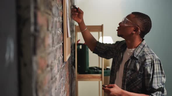 Young AfricanAmerican Man Checks Todo List Near Brick Wall