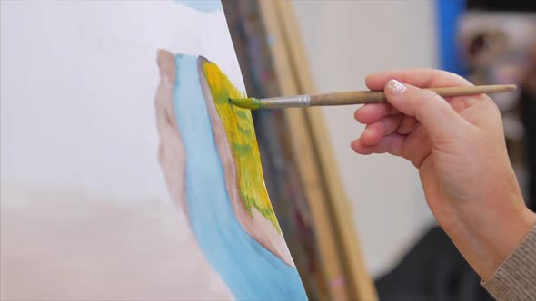 Hands of the Artist, a Female Artist Paints a Canvas with a Brush, Sits at an Easel and Makes Brush