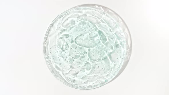 Rotation of Transparent Blue Cosmetic Gel Fluid with Bubbles in a Glass Bowl of Petri