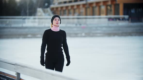 Ice Skating  Young Woman Slowly Walks Out on the Ice Rink