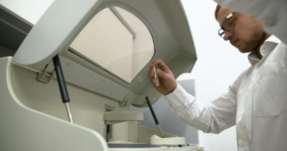 Scientist in Laboratory Examining Liquid in Glass Beaker