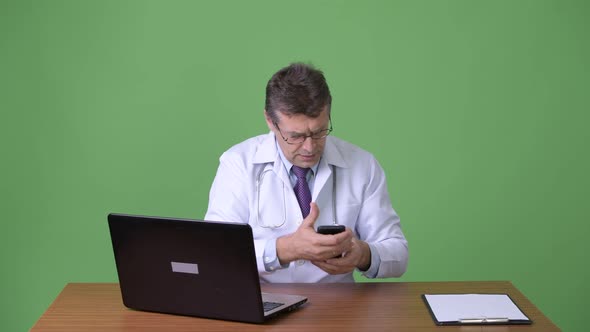 Mature Handsome Man Doctor Against Green Background