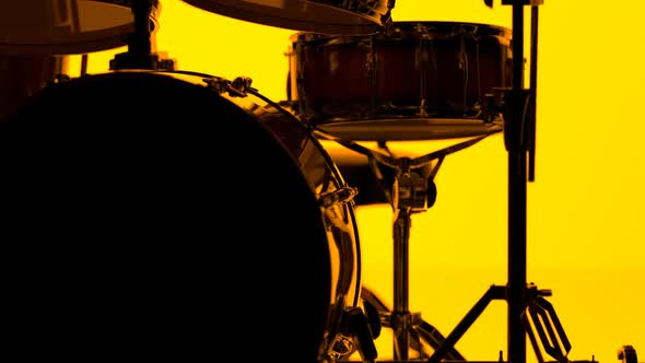 Details of drum kit on a bright orange background. Percussion chrome hardware.