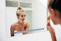 Female putting on moisturizer on her facial skin - PhotoDune Item for Sale
