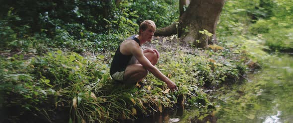 Man plays with water from the river