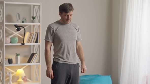 Middle Shot of Concentrated Man Stretching Neck Exercising at Home in the Morning