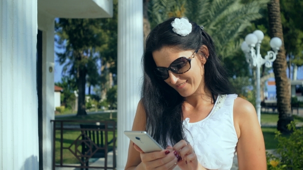 Woman Typing on the Smartphone in Tropical Garden. Vacation