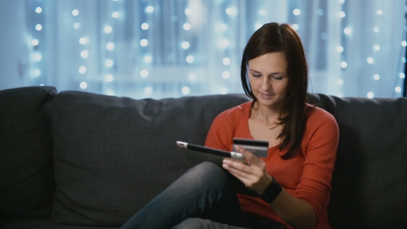 Woman Shopping Online Using a Credit Card Tablet Pc and Mobile App Medium Shot