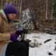 Young Woman Pours Tea From a Thermos Near a Stream in the Winter Forest - VideoHive Item for Sale
