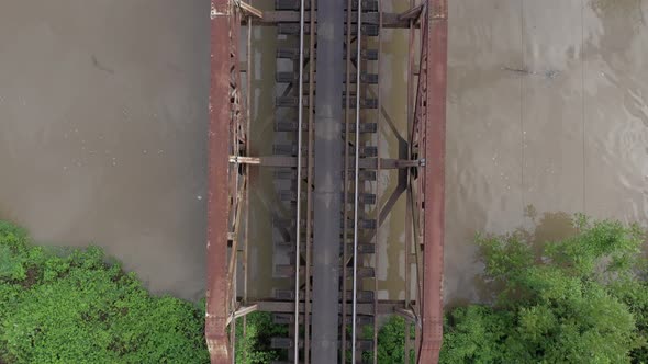 Rusty railway bridge over the river from above 4K aerial video