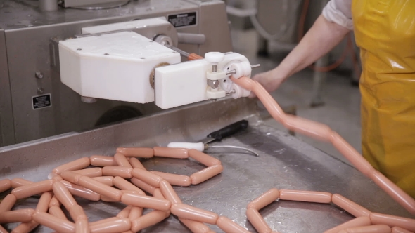 Food Factory. Worker Produces Sausages on a Automated Food Production Equipment.