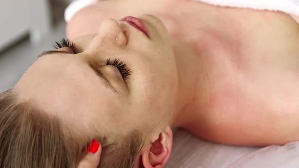Beautician cosmetologist makes relaxing head massage professional procedure in a beauty clinic