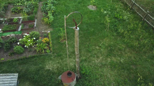 Flight Over The Old Village Well. Lifting Mechanism From The Wheel. Aerial Photography.