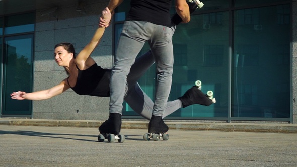 Feet of roller skaters doing acrobatic tricks on street