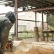 Man Cuts Wood Chainsaw for Future Home. Protective Face Mask on the Face of the Builder and a Lot of - VideoHive Item for Sale