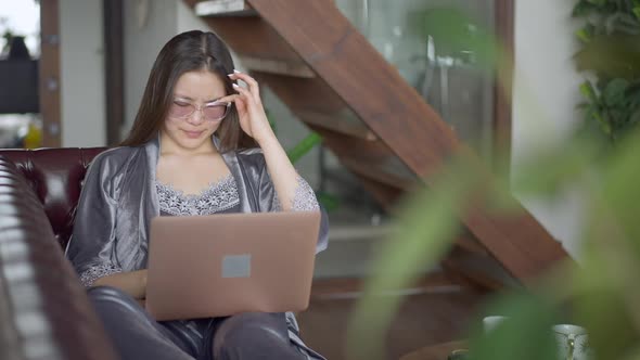 Portrait of Young Overworking Asian Woman Rubbing Eyes Closing Laptop and Stretching Smiling