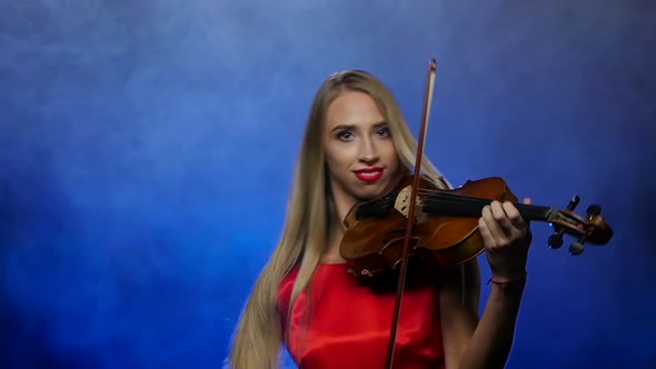 Woman Blonde Plays the Fiddle, Smoky Background, Slow Motion