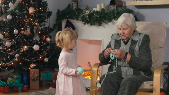 Grandmother Knits a Sock While Sitting in a Chair