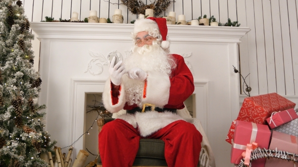 Happy Santa Claus Checking Up Christmas Emails From Kids on His Phone