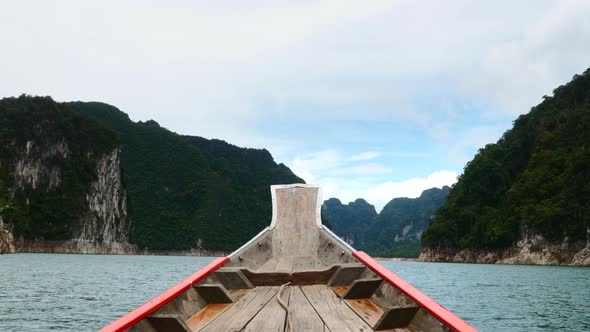 Traveling on Wooden Boat a Blue Lake with Limestone Cliffs and Green Rain Forest