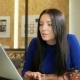Attractive Woman Working in an Office at the Computer. She Looks Into the Camera and Smiling. Long - VideoHive Item for Sale