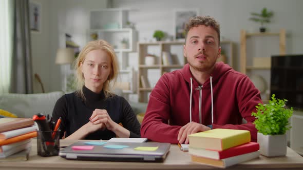 Young Man and Young Woman Together Blogging While Sitting at the Desk at Home in the Living Room