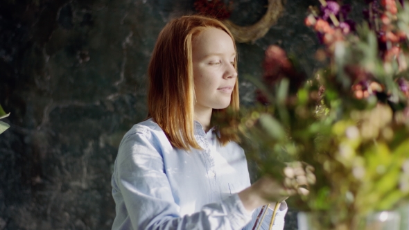 Ginger Florist Arranging Bunch of Flowers Attentively