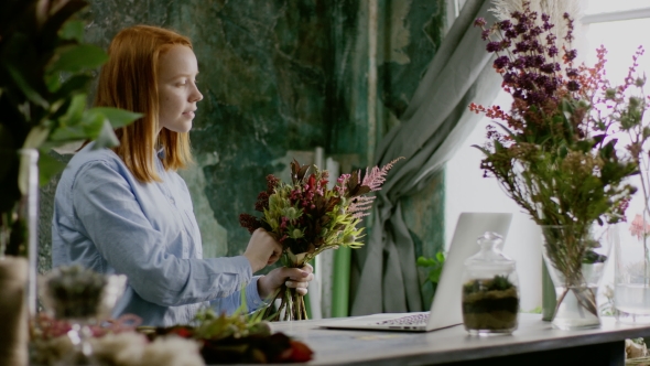 Ginger Florist Creaiting Bouqet Near Table in Office