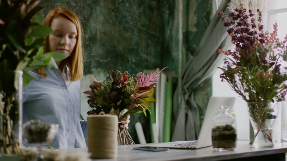 Ginger Florist Arranging Bunch of Flowers Near Computer