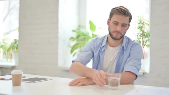 Young Creative Man Drinking Water in Modern Office