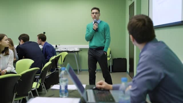 Male Student in Classroom Having an Examination at the University. Young Economist Presents