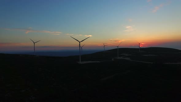 Aerial view of white elegant windmills at sunset
