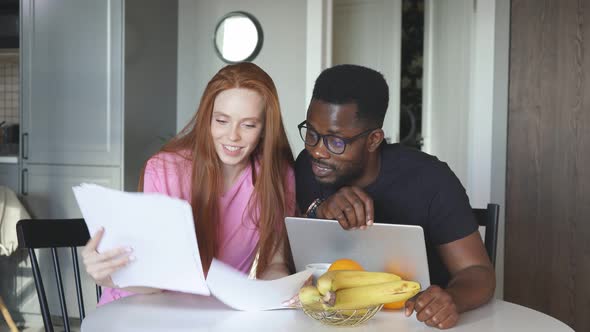 Interracial Couple Reading Mail and Checking Accounting at Home