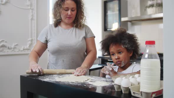 Family Baking  Black Little Girl and Her Mother Rolling Out the Dough with a Skipping Rope