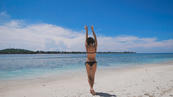 Sexy Brunnete in Black Bikini Bathing in the Sun on the Beach of Bali Island in Hot Summer Day. Fit