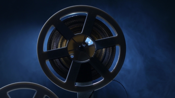 Film Is Wound Onto a Reel Projector. Dark Background with Backlight alt