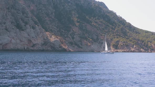 View of Yacht Near Rocky Island of Mallorca or Ibiza