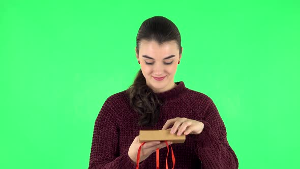 Girl Opens the Gift, Very Surprised and Rejoices. Green Screen