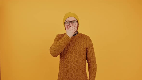 Shocked Man in His 30s Covering the Mouth with One Hand Worries or Troubles Studio Shot Over Orange