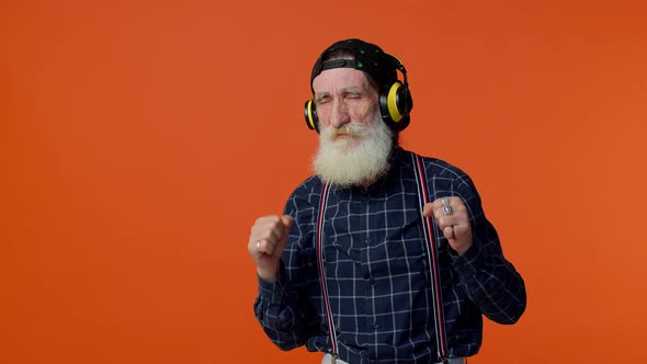 Elderly Old Man Listening Music on Headphones Dancing Disco Fooling Having Fun Gesticulating Hands