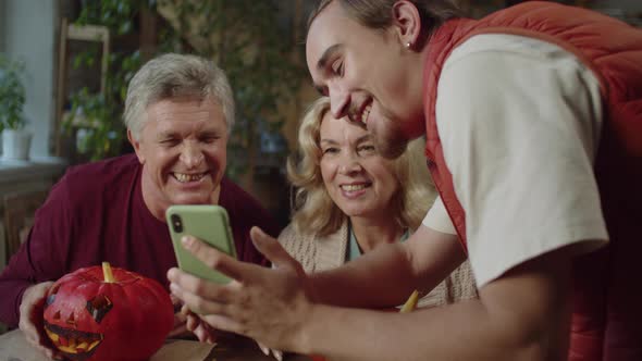 Elderly Parents and Their Son are Watching Photos They Took