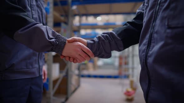 Handshake of Two Unrecognizable Caucasian Men in Warehouse Indoors