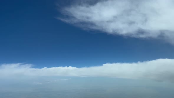 Unique pilot point of view while flying through a blue summer sky and avoiding some fluffy clouds. D