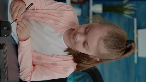 Vertical Video Portrait of Child Doing Homework on Notebook for Education