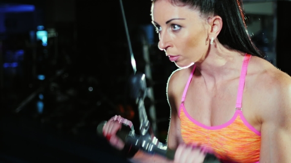 Determination and Motivation: Athletic Woman at the Gym Trains Hands. Female Bodybuilding