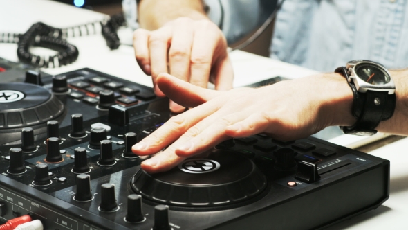 Disc Jockey's Hands While He Changes Settings of the Sound Control System
