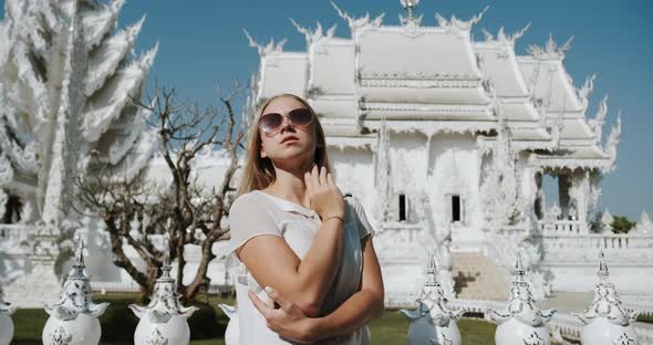 Woman Posing in Front of White Temple Wat Rong Khun in Chiang Rai Thailand